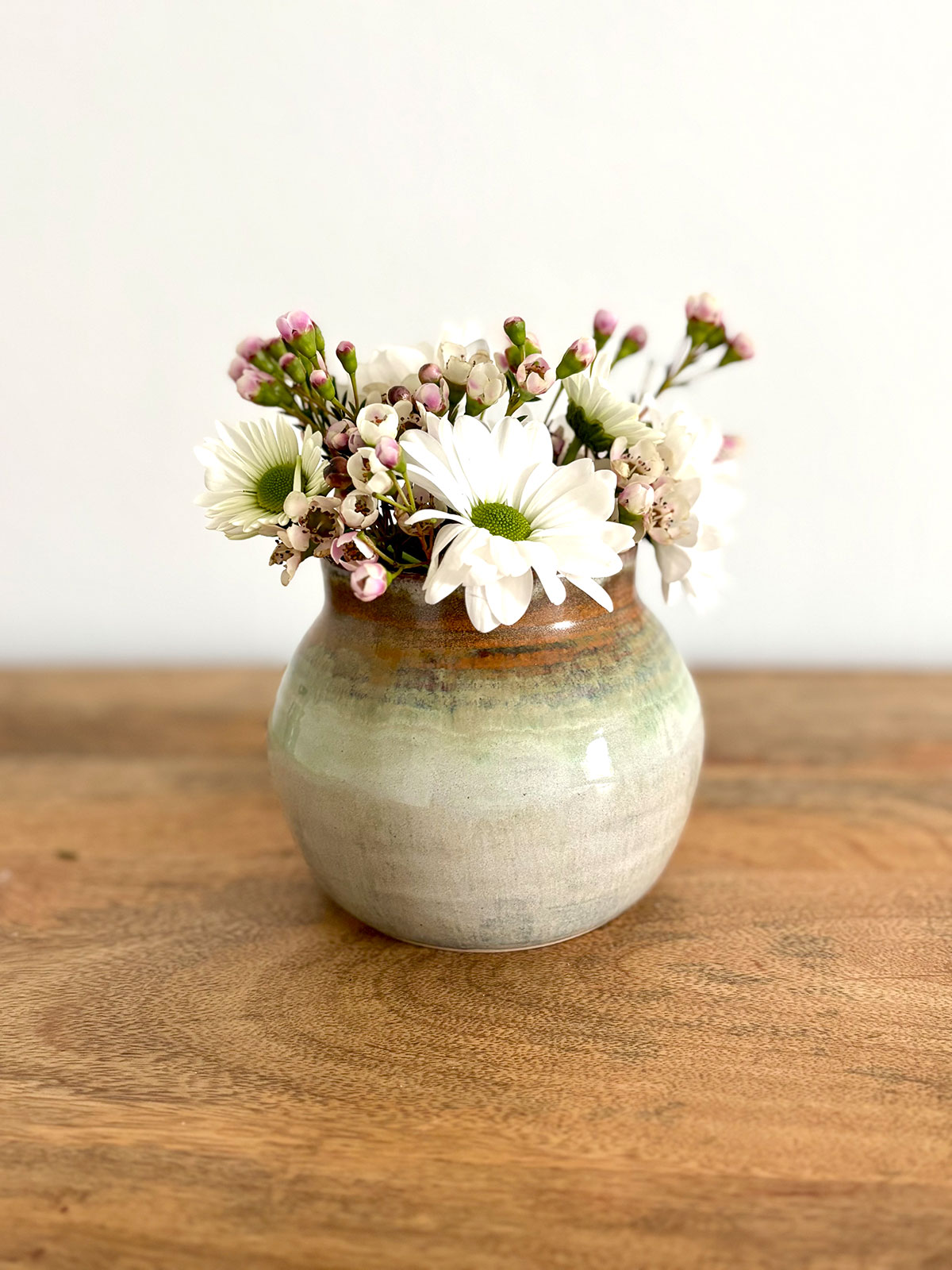 Pretty pottery vase with spring flowers